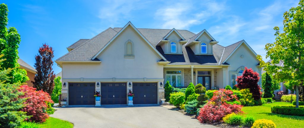 Exterior of a home with blue sky and green trees, representing selling your home